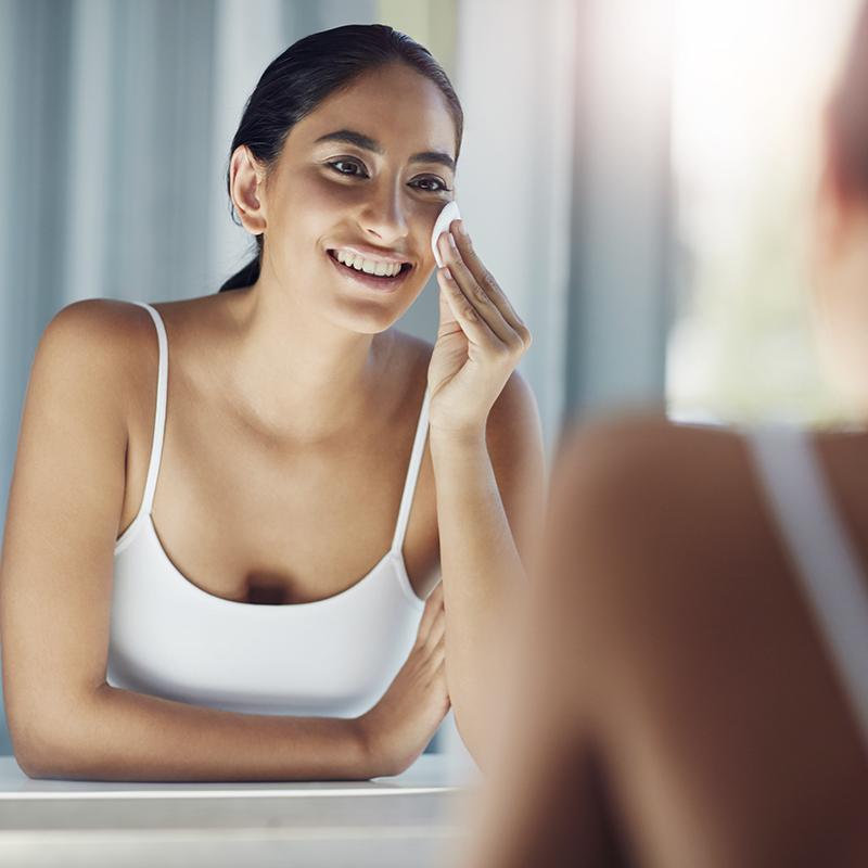 Woman cleaning her face with a pad